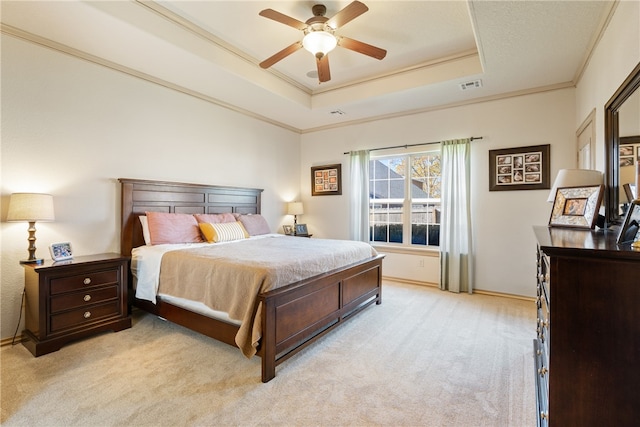 bedroom featuring a tray ceiling, ceiling fan, light carpet, and ornamental molding