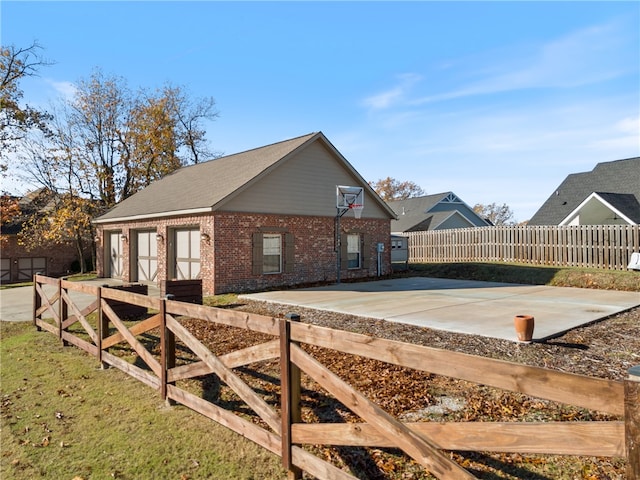 view of side of home featuring basketball court