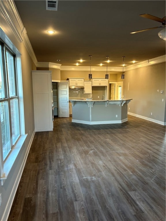 kitchen with crown molding, plenty of natural light, a spacious island, and decorative light fixtures