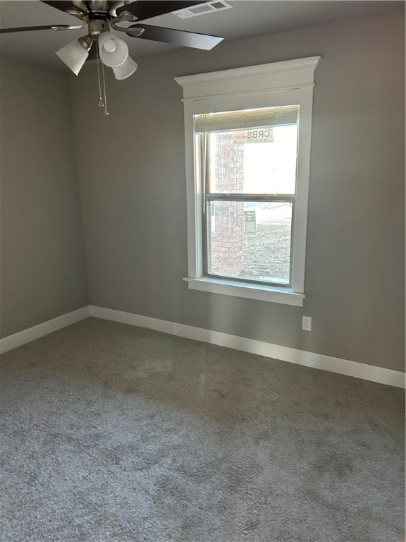 carpeted spare room with ceiling fan