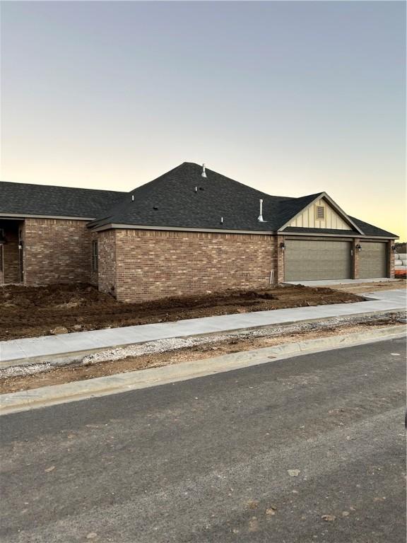 4833 W Planetree St, Fayetteville, AR 72704 - view of front of house featuring brick siding, a garage, concrete driveway, and roof with shingles