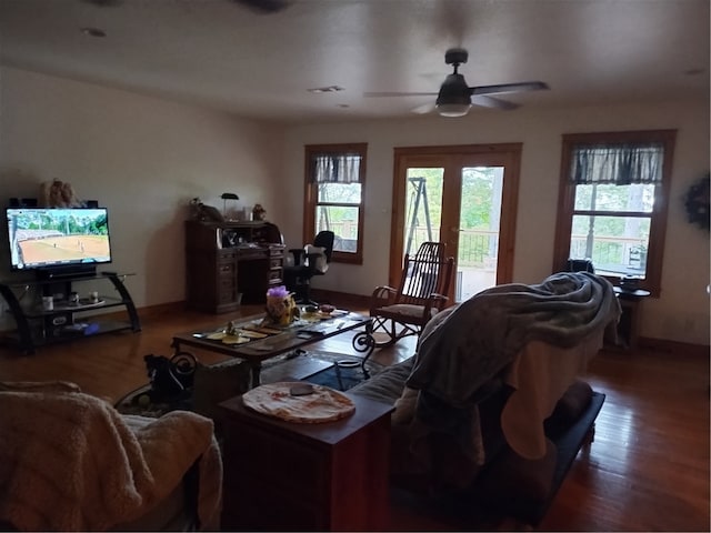 living room featuring a wealth of natural light, dark wood-type flooring, and ceiling fan