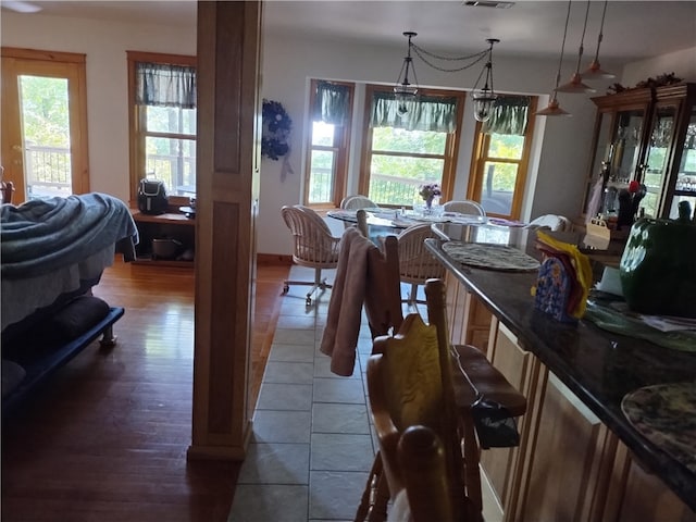 dining space featuring plenty of natural light, dark hardwood / wood-style floors, and an inviting chandelier