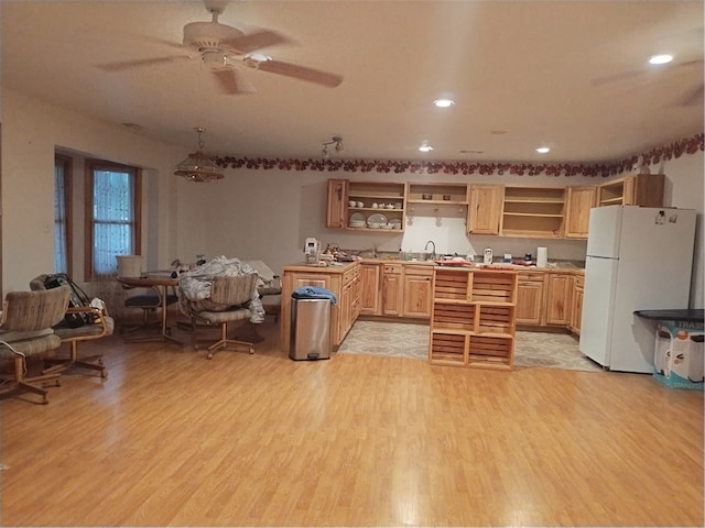 kitchen featuring light brown cabinets, white refrigerator, hanging light fixtures, ceiling fan, and light hardwood / wood-style floors