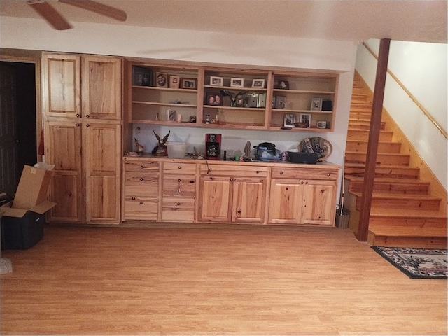 bar with ceiling fan and light hardwood / wood-style floors