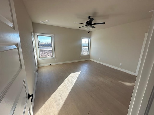 unfurnished room with ceiling fan, a healthy amount of sunlight, and wood-type flooring