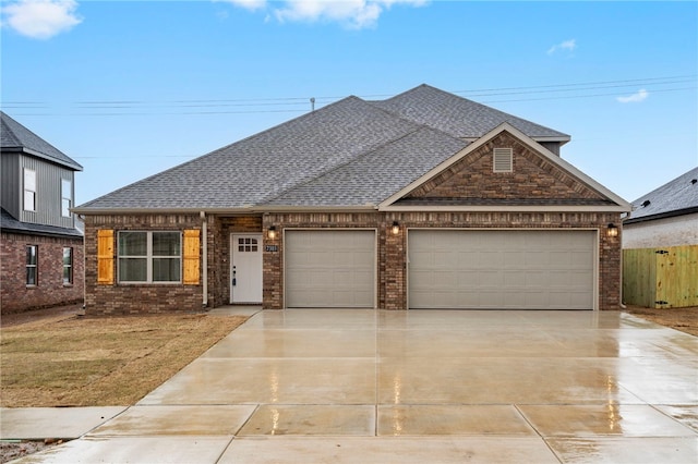 view of front of home with fence, an attached garage, concrete driveway, brick siding, and a shingled roof