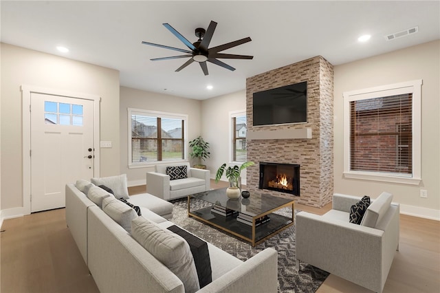 living room featuring recessed lighting, visible vents, a ceiling fan, a fireplace, and wood finished floors