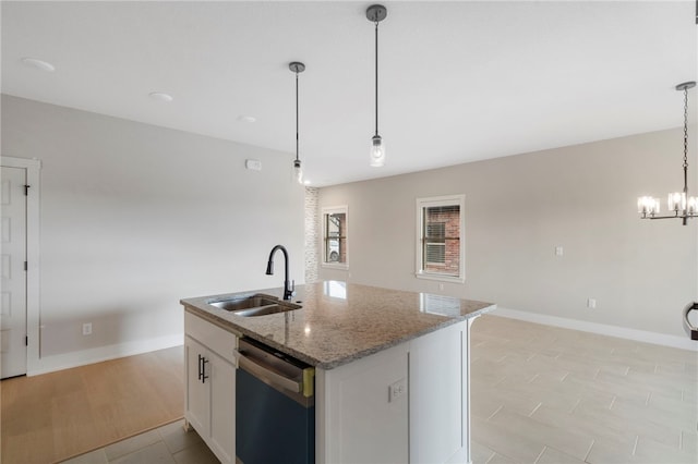 kitchen featuring a sink, stainless steel dishwasher, a center island with sink, white cabinets, and an inviting chandelier