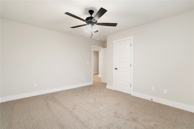 carpeted empty room featuring baseboards and ceiling fan