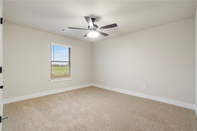 carpeted empty room featuring visible vents, baseboards, and ceiling fan