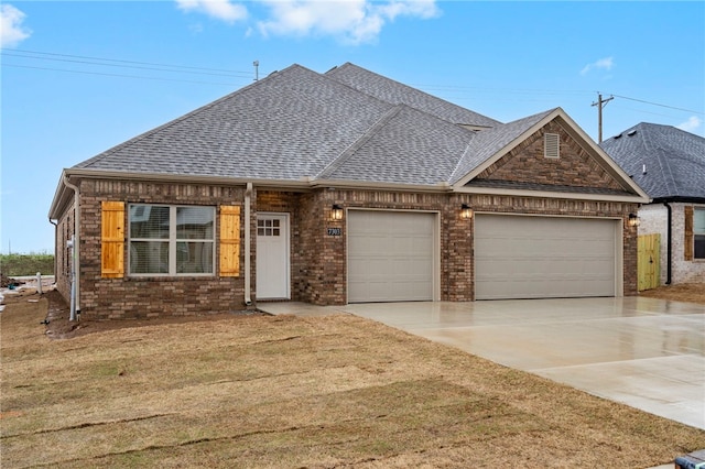 view of front of property with a front yard, concrete driveway, brick siding, a shingled roof, and a garage