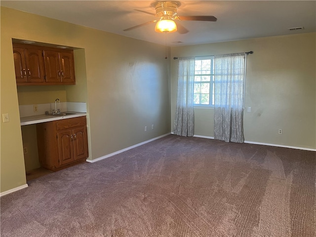 interior space with ceiling fan, sink, and carpet