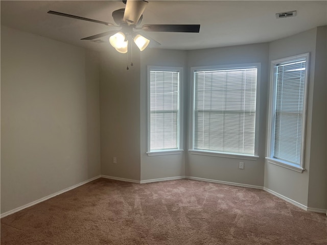 carpeted spare room with ceiling fan