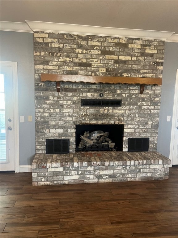 interior details with crown molding, hardwood / wood-style floors, and a brick fireplace