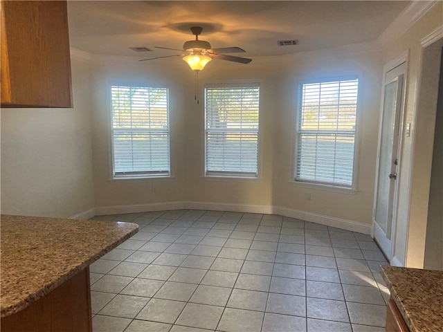 unfurnished dining area featuring light tile patterned floors, ceiling fan, and a healthy amount of sunlight