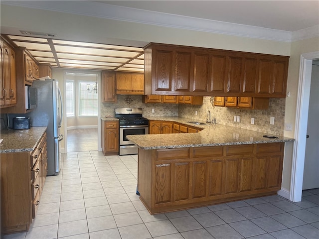 kitchen with backsplash, kitchen peninsula, crown molding, and appliances with stainless steel finishes