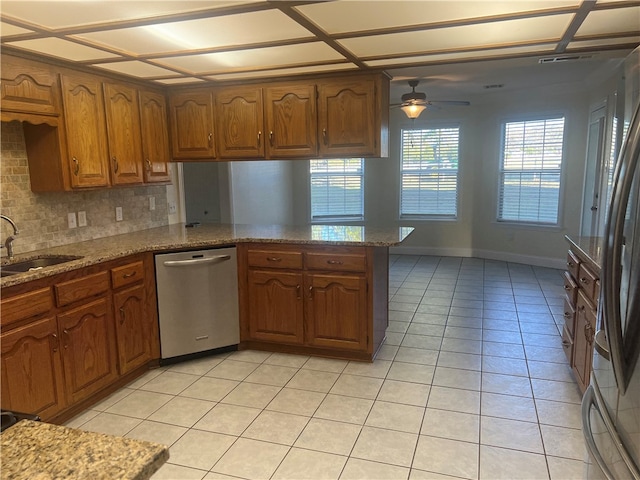 kitchen featuring kitchen peninsula, appliances with stainless steel finishes, tasteful backsplash, ceiling fan, and sink