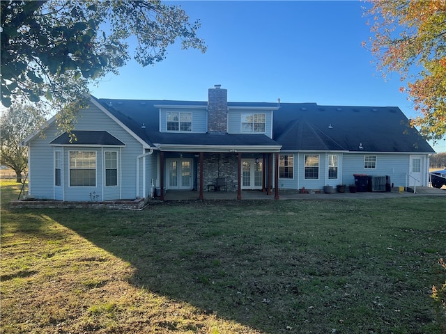 rear view of house featuring a lawn and a patio