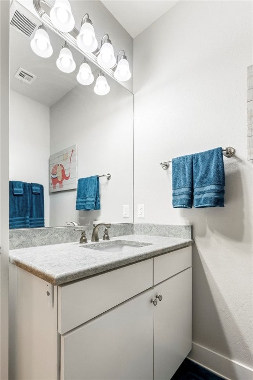 bathroom with vanity, visible vents, and baseboards