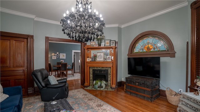 living room with a notable chandelier, a premium fireplace, crown molding, and light hardwood / wood-style flooring