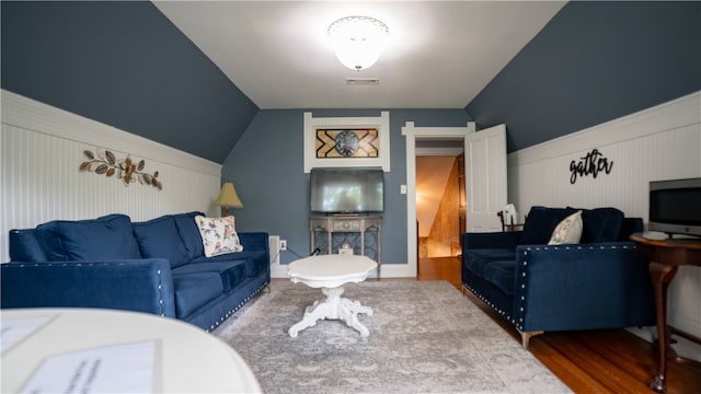 living room featuring hardwood / wood-style flooring and vaulted ceiling