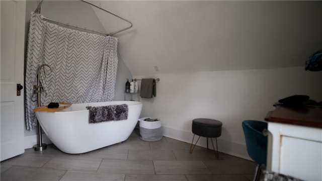 bathroom featuring vaulted ceiling and a bathtub