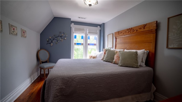 bedroom with hardwood / wood-style floors and vaulted ceiling