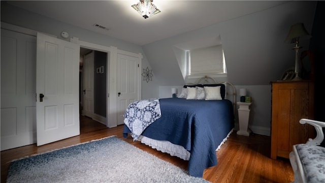 bedroom with dark hardwood / wood-style floors and vaulted ceiling