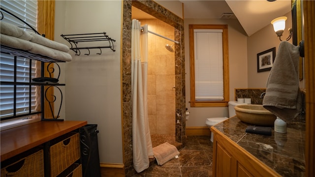 bathroom featuring vanity, toilet, and curtained shower