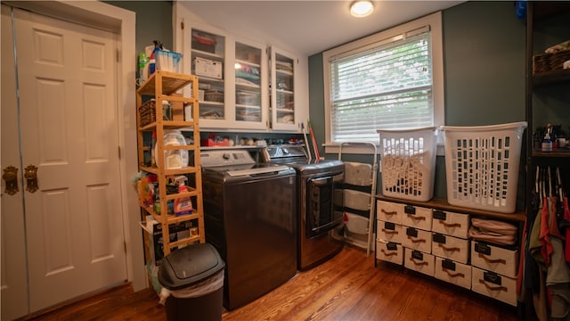 washroom featuring separate washer and dryer, cabinets, and wood-type flooring