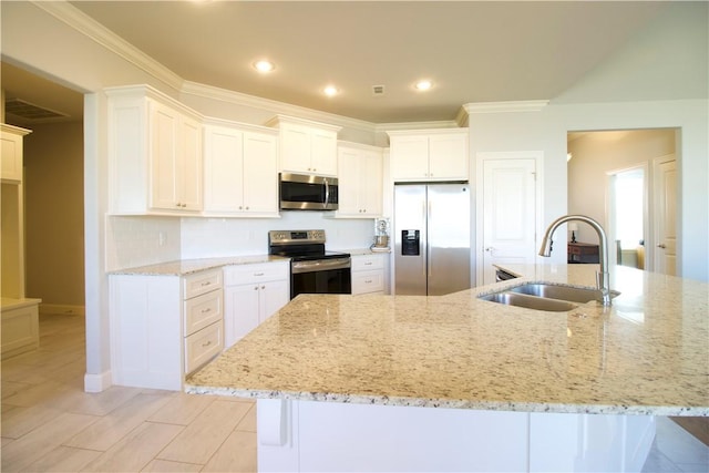 kitchen with white cabinets, appliances with stainless steel finishes, light stone countertops, and sink