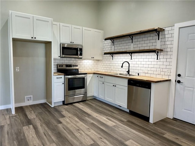 kitchen with white cabinets, wood counters, dark hardwood / wood-style floors, and stainless steel appliances