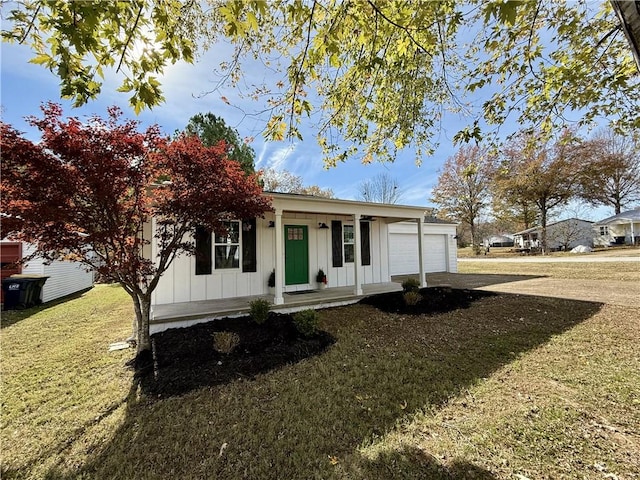 view of front of home featuring a porch, a garage, and a front yard