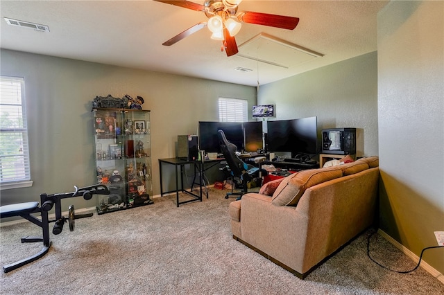 living room featuring carpet, ceiling fan, and a wealth of natural light