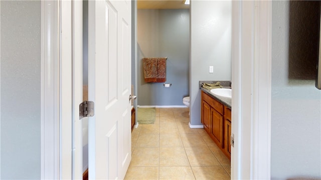 bathroom with tile patterned flooring, vanity, and toilet