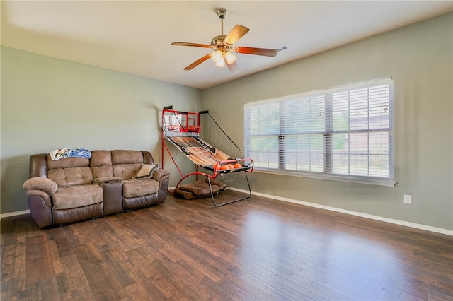 living room with ceiling fan and dark wood-type flooring