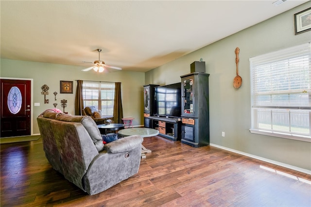 living room featuring plenty of natural light, ceiling fan, and dark hardwood / wood-style flooring