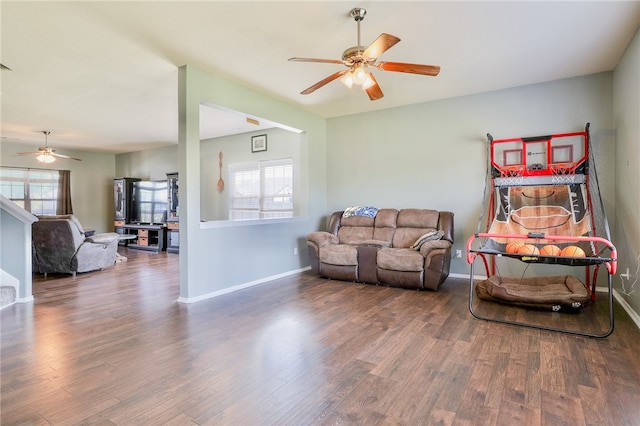 living room featuring ceiling fan and dark wood-type flooring