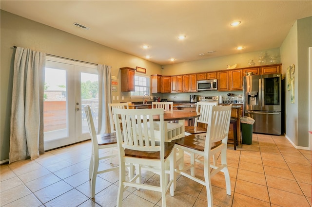 tiled dining space featuring french doors and sink