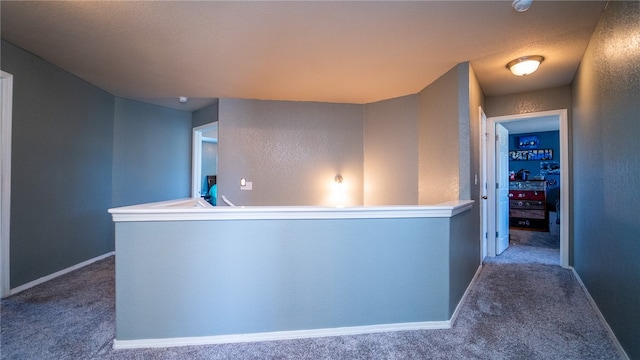 corridor with carpet flooring and a textured ceiling