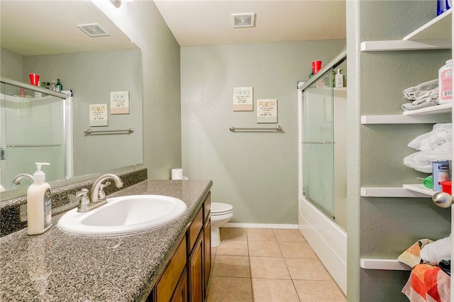 full bathroom featuring tile patterned floors, vanity, toilet, and shower / bath combination with glass door