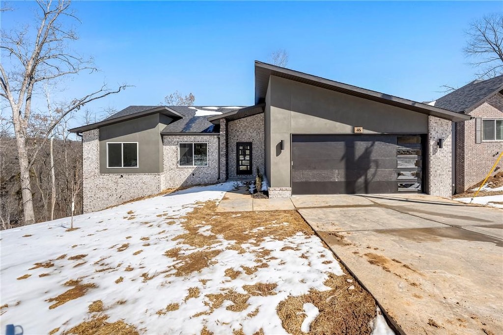 view of front facade featuring a garage, concrete driveway, and stucco siding