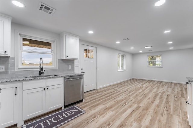 kitchen with white cabinetry, stainless steel dishwasher, light stone counters, and light hardwood / wood-style floors