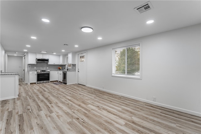 kitchen with white cabinets, stainless steel appliances, light hardwood / wood-style floors, and exhaust hood