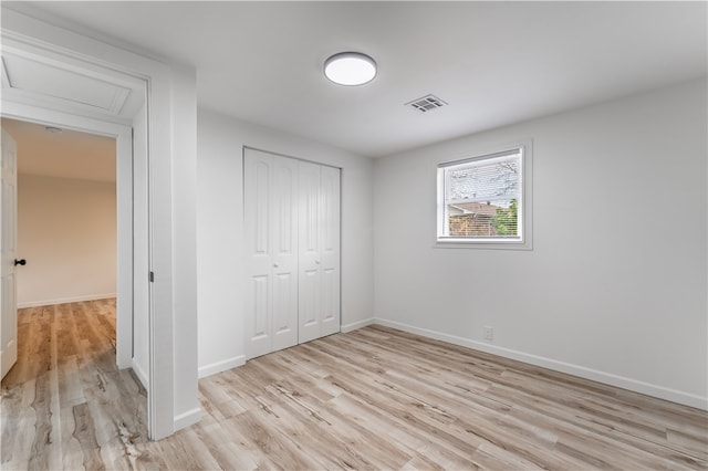 unfurnished bedroom featuring light hardwood / wood-style floors and a closet