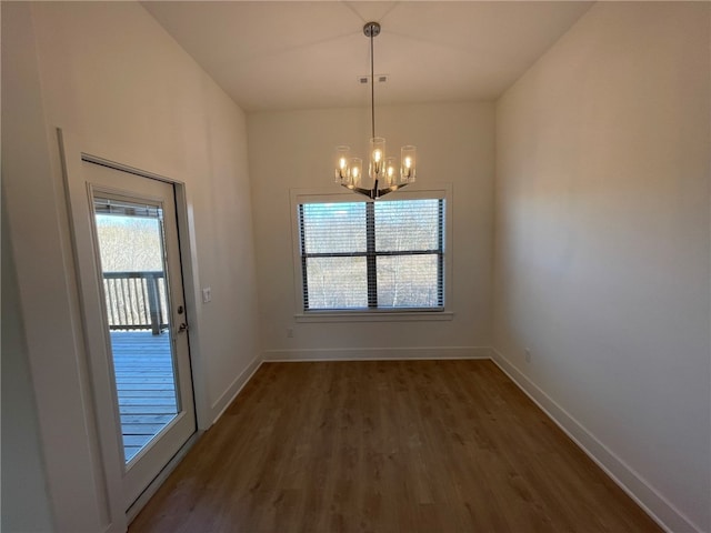 unfurnished dining area with a wealth of natural light, dark hardwood / wood-style flooring, and a chandelier