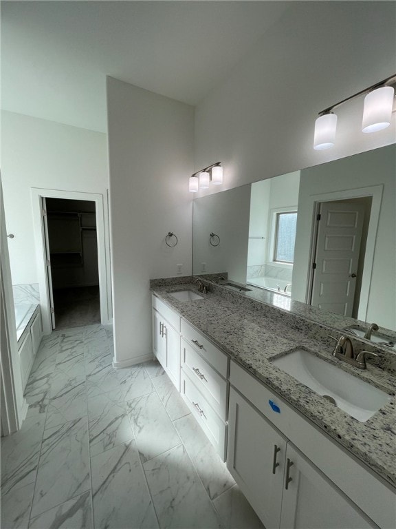 bathroom with a tub and vanity