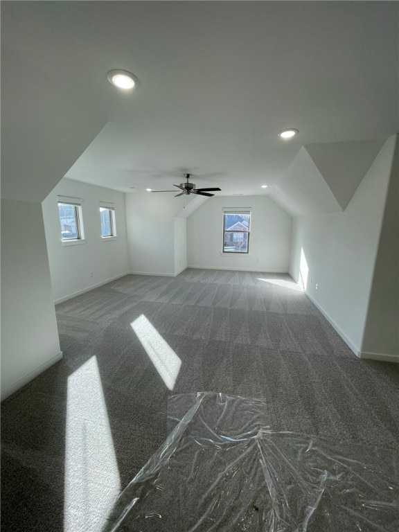 bonus room with dark colored carpet, ceiling fan, and lofted ceiling