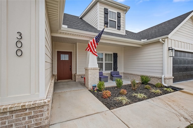 entrance to property featuring a porch and a garage